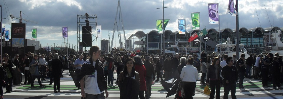 A man and a woman stand in the foreground of a large crowd of pedestrians